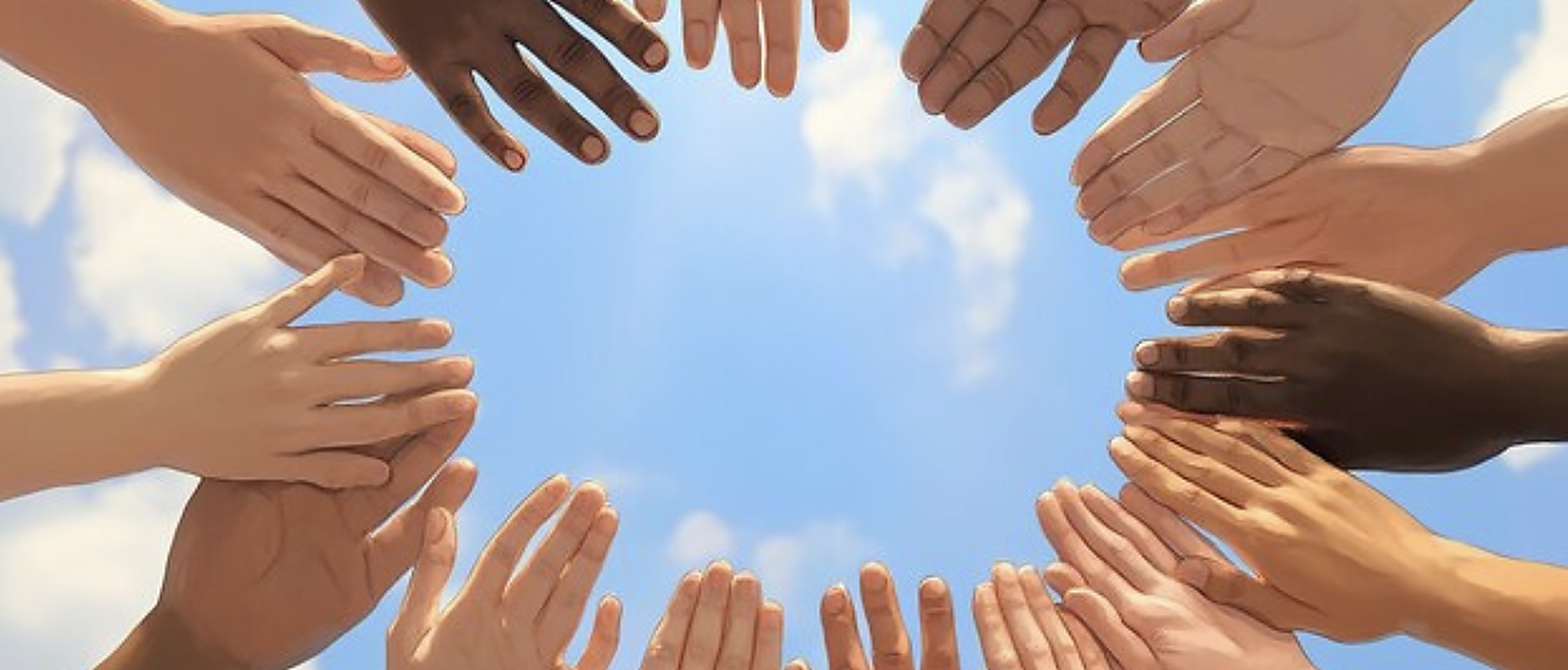 Hands of many colors reaching together toward the sky